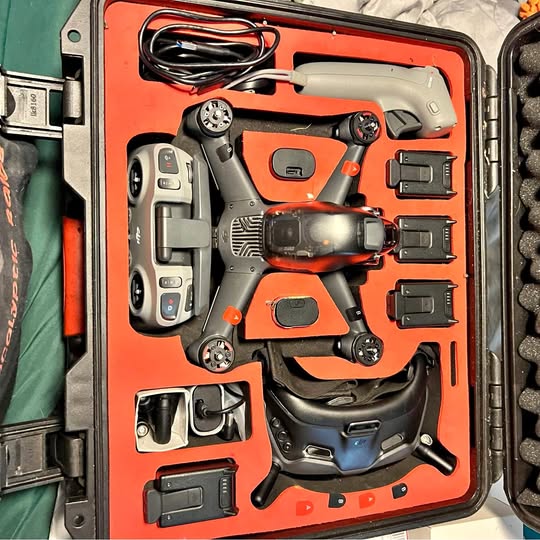 Orange DJI FPV drone with remote controller and spare batteries in hard case