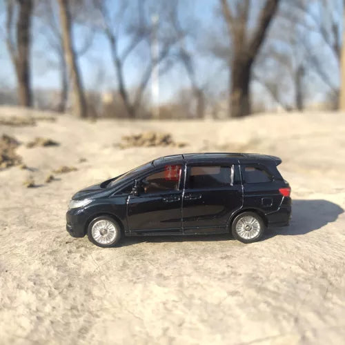 Black diecast minivan model car in side profile with detailed wheels.