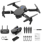 Gray quadcopter drone with camera, remote controller, spare propellers and tools