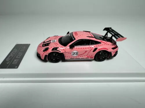 Pink diecast sports car model with rear wing, number 23, open cockpit detail