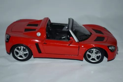 Red diecast sports car model with open doors and black interior details