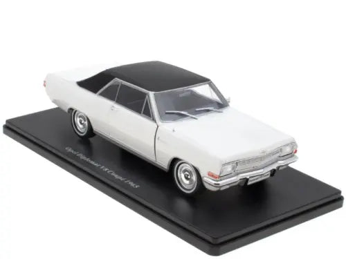 White vintage diecast coupe model car with black roof on black display base