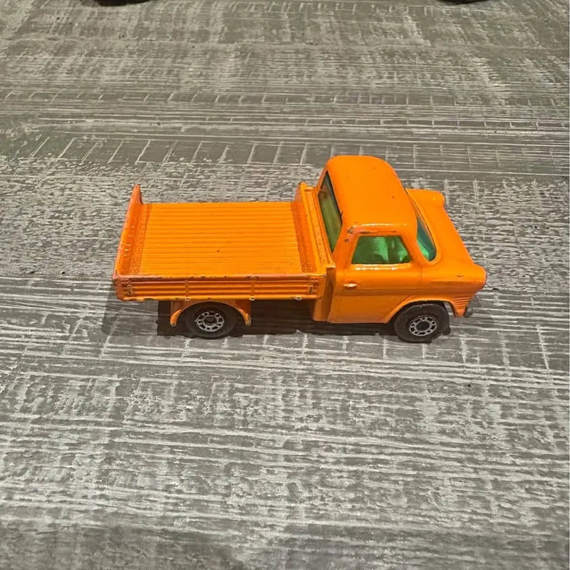 Orange diecast dump truck with open cargo bed and black wheels