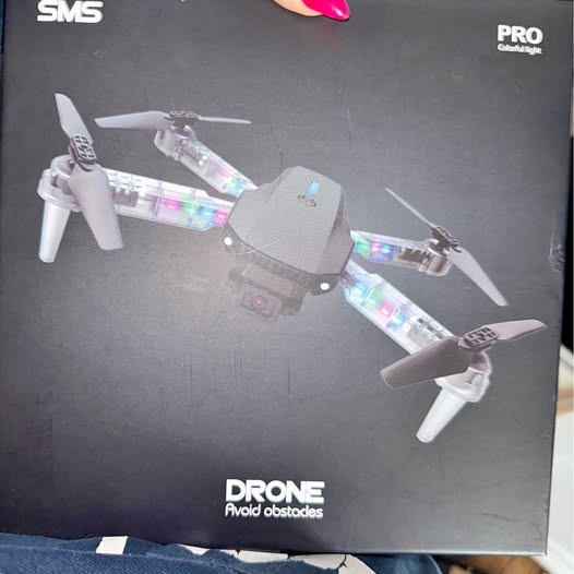 Foldable quadcopter drone with four propellers on packaging front
