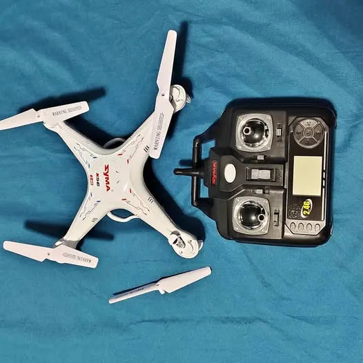 White RC drone with visible propellers and handheld controller transmitter