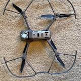 Compact quadcopter drone with four propellers and center camera module