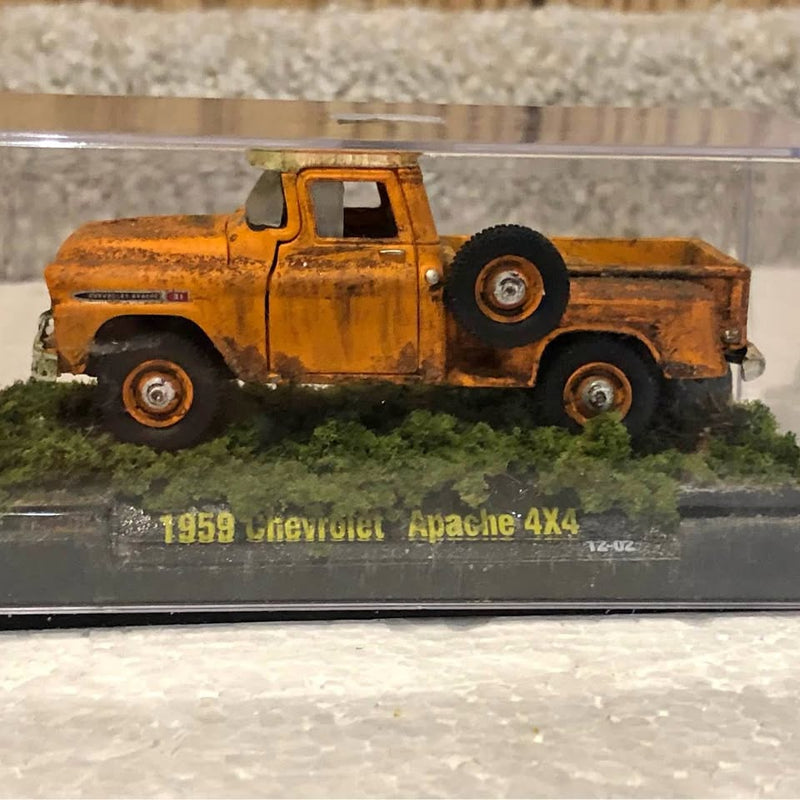 Rusty orange 1959 Chevy Apache 4x4 diecast pickup truck on display base