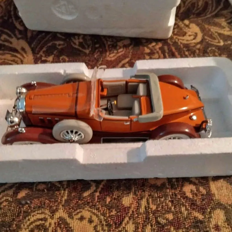 Orange diecast classic car model in display packaging tray