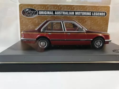 1/43 scale diecast Holden sedan model, maroon with chrome wheels, side view.