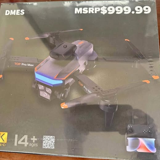 Grey quadcopter drone with camera and LED lights, in box