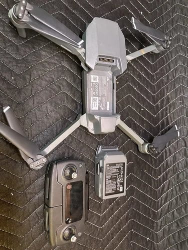DJI Mavic Pro drone with battery pack and fold-out propellers on gray fabric