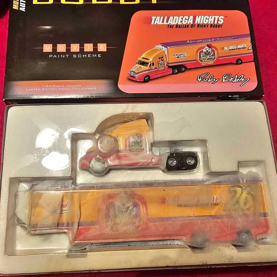 Diecast hauler vehicle in blister pack, orange bus and white trailer body
