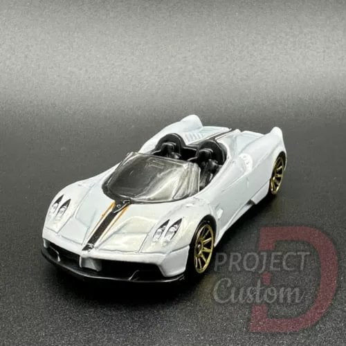 White diecast roadster with black windshield and gold wheels, front view