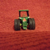 Green John Deere diecast tractor toy with black rubber tires