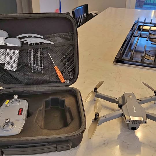 Folding drone with camera and GPS, shown with open hard carrying case