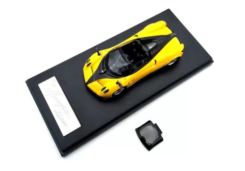 Yellow diecast roadster model car in black display case