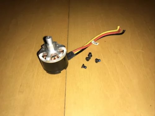 Silver drone motor with attached red and black wires and small screws