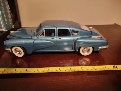 Vintage diecast 1/18 Tucker car in torpedo blue, front-left view, detailed wheels