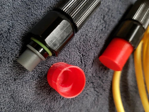 Red protective dust cap cover for underwater drone connector, with cable fitting visible