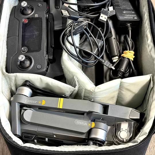 Drone kit case with remote controller, drone body, and charging cables