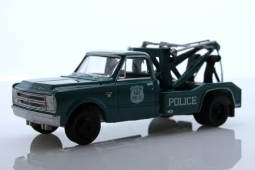 Dark green police wrecker tow truck diecast model with lifting boom