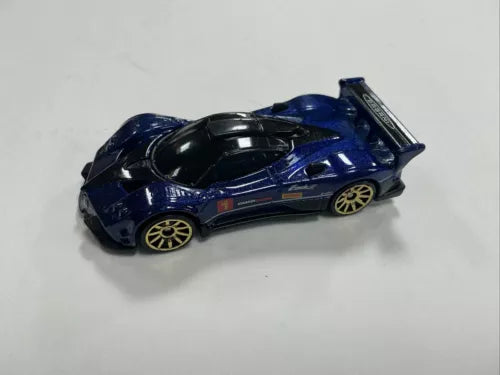 Diecast race car with dark blue and black body, gold wheels, side view