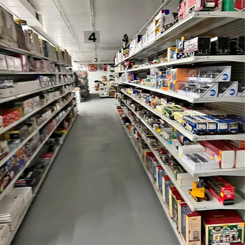 Indoor flea market aisle with trading card and video game shelves
