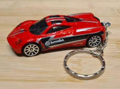 Red diecast model car keychain with black hood and chrome keyring loop