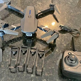 Foldable drone with camera, with propellers and remote controller beside it