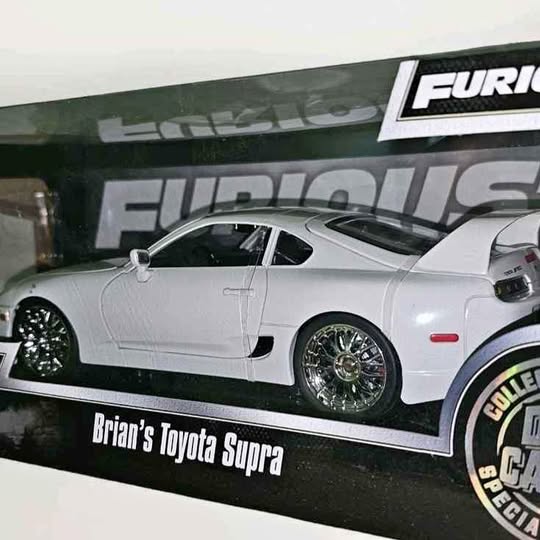 White diecast sports car model with black wheels, side view