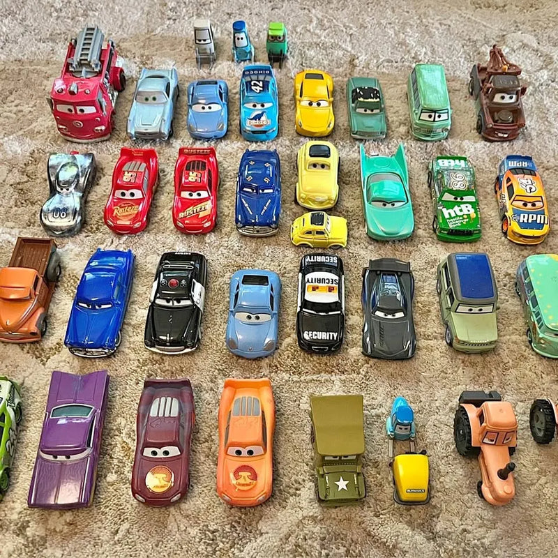 Diecast car lot with assorted colored vehicles, shown in a grid on concrete
