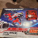 FPV racing drone retail box with red propeller guards and spare blades