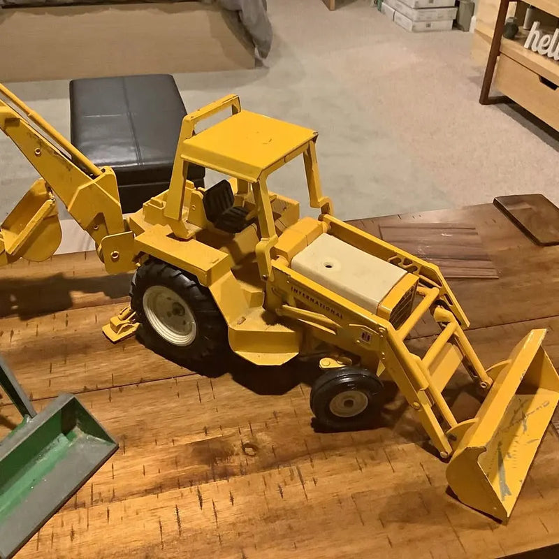 Yellow diecast front loader toy with front bucket and black tires
