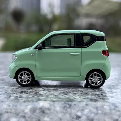 Green 1/64 scale diecast mini EV car model, side view with silver wheels