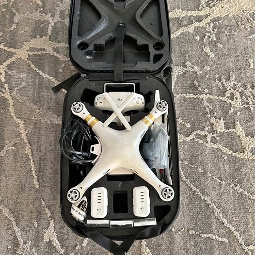 White DJI Phantom 3 drone with landing gear in hard case, top view.