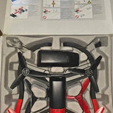 Quadcopter drone in packaging, black body with red accents and four black propellers
