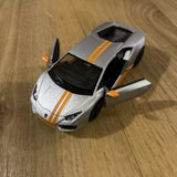 Silver diecast toy car with black top and orange racing stripes, front doors open