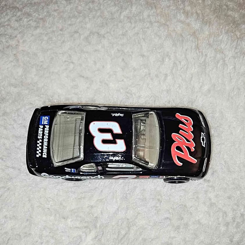 Die-cast toy car, black with colorful decals and detailed grille, compact size.