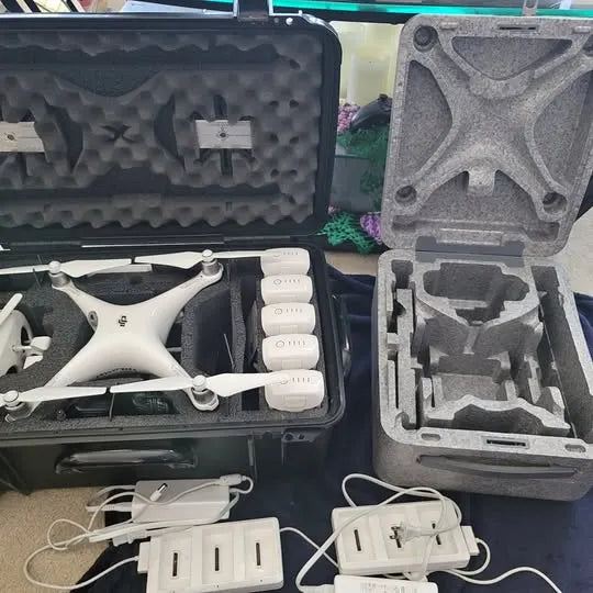 DJI Phantom 4 Pro drone in open case with white propellers and batteries