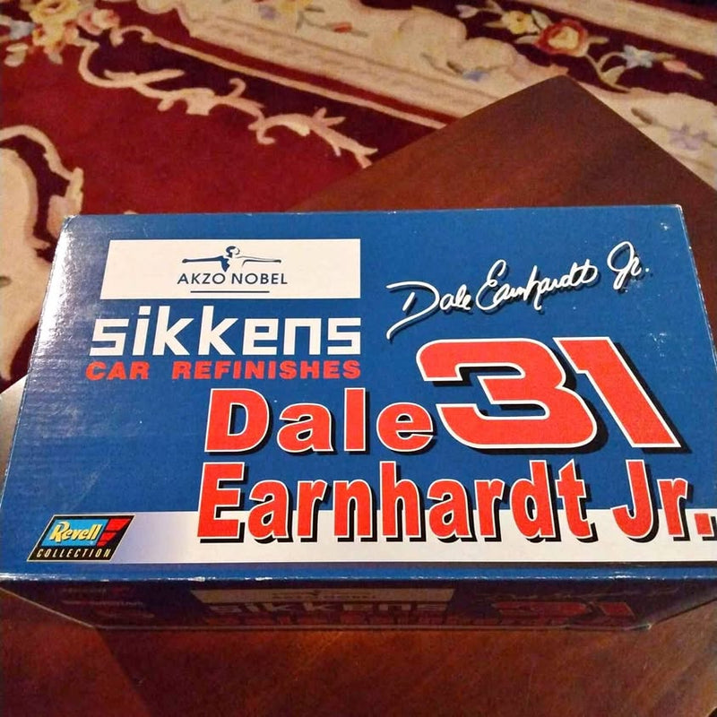 Blue collectible diecast box with red and white lettering and logo