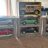 Vintage diecast car in box with green top car and black bottom car, unopened