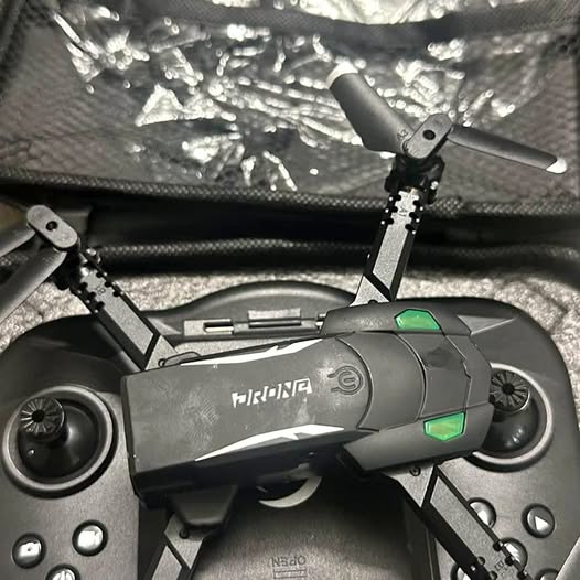 Grey drone with green indicator lights and four propellers