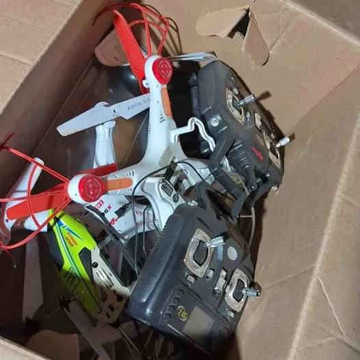 Cardboard box with mixed drone parts and propellers