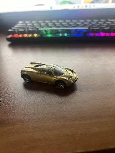 Hot Wheels 2012 Pagani Huayra loose diecast car, gold with black racing stripe