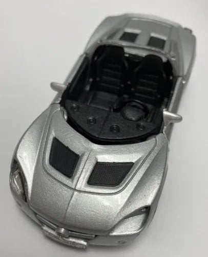 Silver diecast car model with open engine bay and detailed black interior