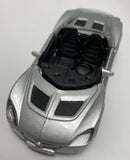 Silver diecast car model with open engine bay and detailed black interior