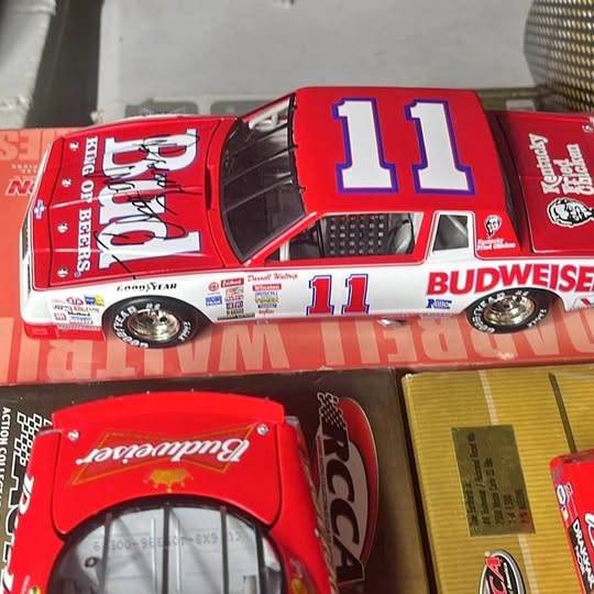 Red NASCAR diecast model car with blue #11 on door and rear deck.