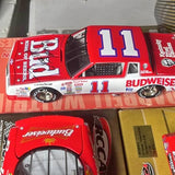 Red NASCAR diecast model car with blue #11 on door and rear deck.