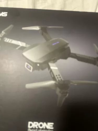 White quadcopter drone with camera and four propellers, close-up view