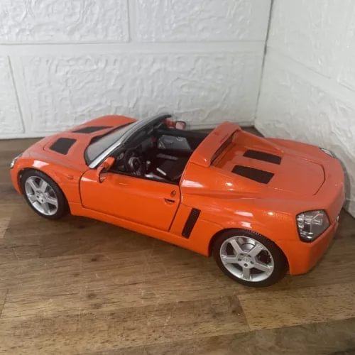 Orange sports car diecast model, 1:18 scale with black hood accents